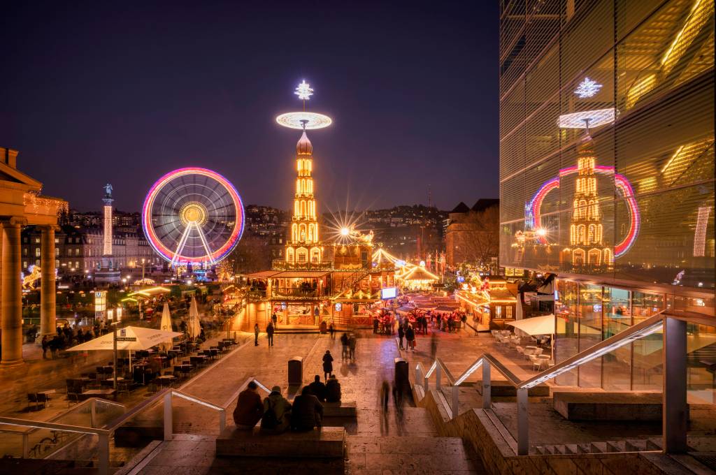 Beleuchtetes Riesenrad und Weihnachtspyramide bei Nacht