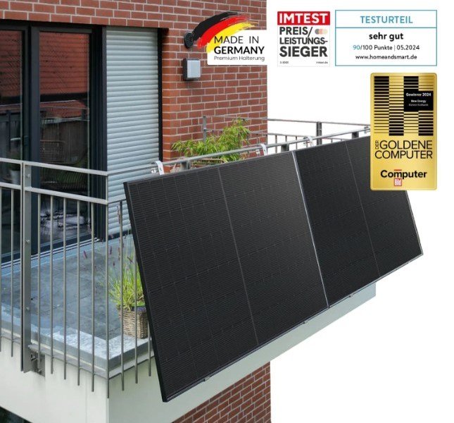 Auf einem Gitterbalkon hängen zwei Solarmodule.